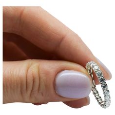 a woman's hand with a diamond ring on her finger and the other hand holding it