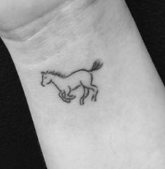 a small horse tattoo on the wrist is shown in black and white, with an outline of a running horse