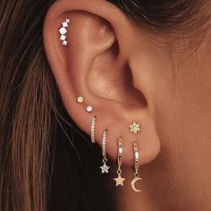 a woman wearing ear piercings with stars and moon