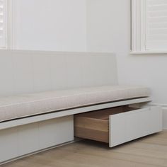 a white bench sitting next to a window