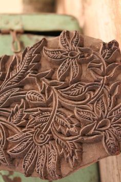 an intricately carved piece of wood with leaves on it