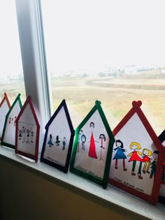 four houses are painted with children's drawings on the side of a window sill