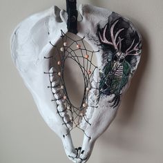 an animal's skull hanging on the wall with beaded decorations and beads around it