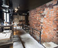 a brick wall in the middle of a restaurant with tables and chairs on either side