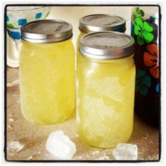 two jars filled with yellow liquid sitting next to each other