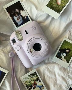 a pink camera sitting on top of a bed next to polaroid pictures and a purple cord