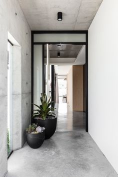 a long hallway with two large planters on either side