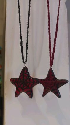 two red and black necklaces hanging on a wall