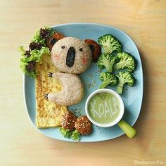 a blue plate topped with food and veggies next to a cup of green liquid