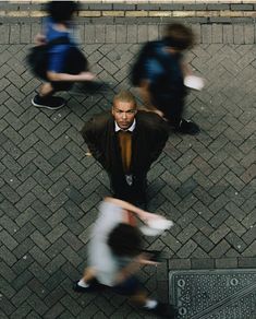 an overhead view of people walking down the street, with one man wearing a suit and tie