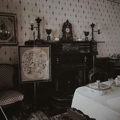 an old fashioned dining room with ornate wallpaper and antique furniture in black and white