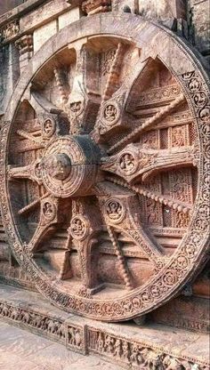 an intricately carved wheel on the side of a building