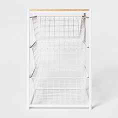 a white shelf with wire baskets on top