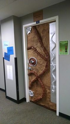 an office hallway with two doors decorated like a piece of paper and some decorations on the door