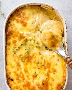 a casserole dish with dumplings in it and a spoon on the side