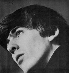 an old black and white photo of a young man with short hair wearing a suit