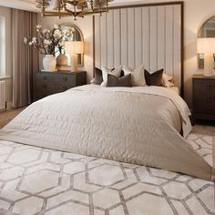 a bedroom with a large bed and chandelier