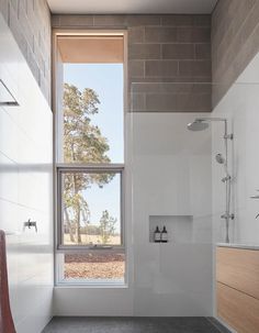 a bathroom with a large window next to a walk - in shower and white walls