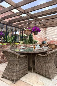 Traditional, elegant rattan dining set dressed with rattan placemats, bowls and wine glasses. Bright flower baskets hang from an overhead pergola. Outdoor Dining Design, Country Garden Design, Dining Design, Traditional Garden, Country Garden