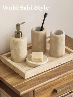 a wooden table with two soap dispensers and a toothbrush holder on it