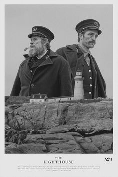 two men standing next to each other in front of a lighthouse