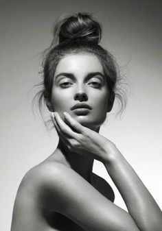 a naked woman with her hands on her chest and arms crossed, posing for a black and white photo