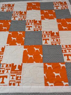 an orange and white dog quilt on a bed