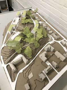 a model of a city with trees, buildings and roads on it's surface