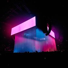 the stage is lit up with pink and blue lights