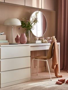 a bedroom with a dresser, mirror and shoes on the floor in front of it