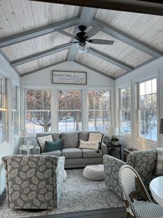 a living room filled with furniture and a ceiling fan in the middle of it's walls