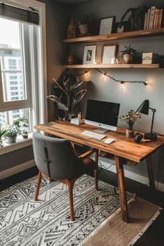 a desk with a computer on it in front of a window and some potted plants