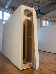 a large white box sitting on top of a hard wood floor in an empty room