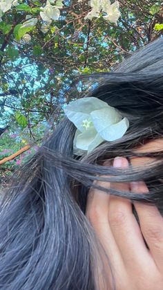 a close up of a person's hair with flowers in it and leaves on top