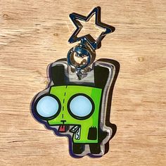 a cartoon character keychain with a star hanging from it's side on a wooden surface