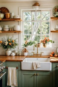 a kitchen with green cabinets and wooden counter tops, white walls and open shelving above the sink