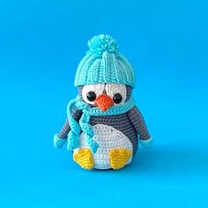 a crocheted penguin wearing a blue hat and scarf