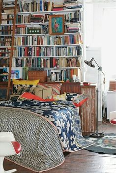 a living room filled with lots of furniture and bookshelves full of different types of books