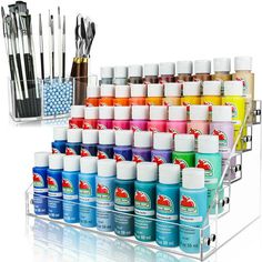 an assortment of pens and markers in a clear holder with acrylic paint on it