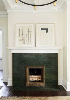 a living room with a fire place and two pictures on the fireplace mantels