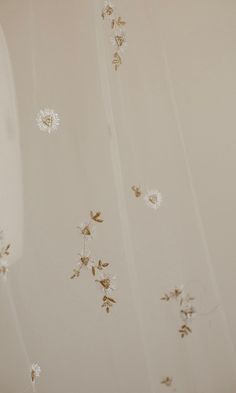 white and gold wallpaper with dandelions on it