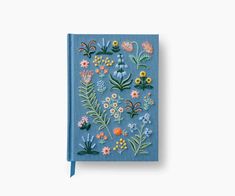 a blue notebook with flowers and plants on it