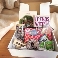 a box filled with lots of items sitting on top of a wooden table