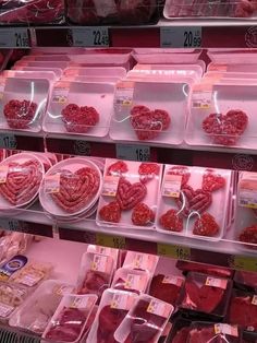 meats are displayed in plastic trays at a grocery store