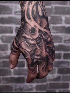 a man's hand with tattoos on it