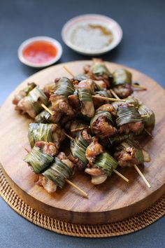 some food is sitting on top of a wooden plate with toothpicks in it