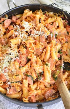 a skillet filled with pasta, meat and parmesan cheese