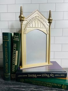 a mirror sitting on top of three books