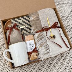 an open box containing coffee, books and other items with a mug on the side