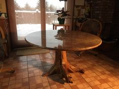 a dining room table that has been made out of wood and is surrounded by tile flooring